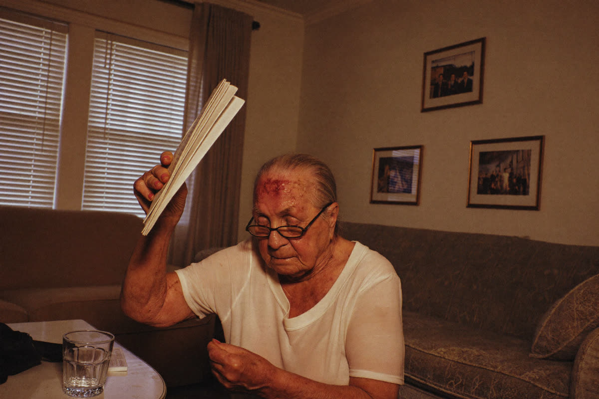 La mère de Julien, 78 ans, s'éventant dans sa maison surchauffée à Marseille après la panne de sa climatisation centrale.